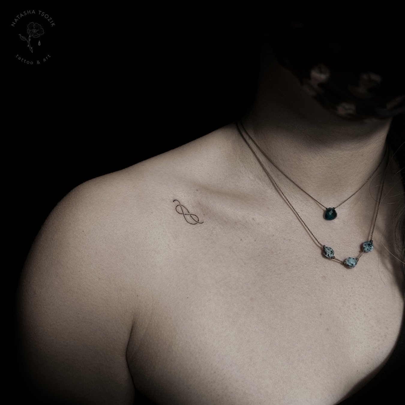 Infinity Small fine line tattoo on collarbone by Natasha Tsozik