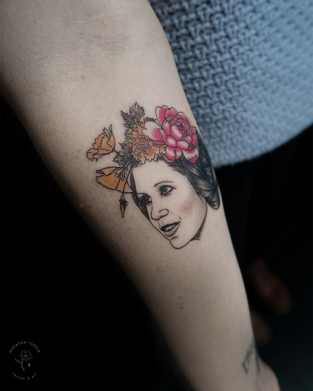 Fine line tattoo on a forearm – a portrait of Princess Leia with flowers by Natasha Tsozik