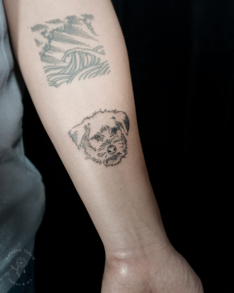 Dog portrait tattoo on a forearm.
