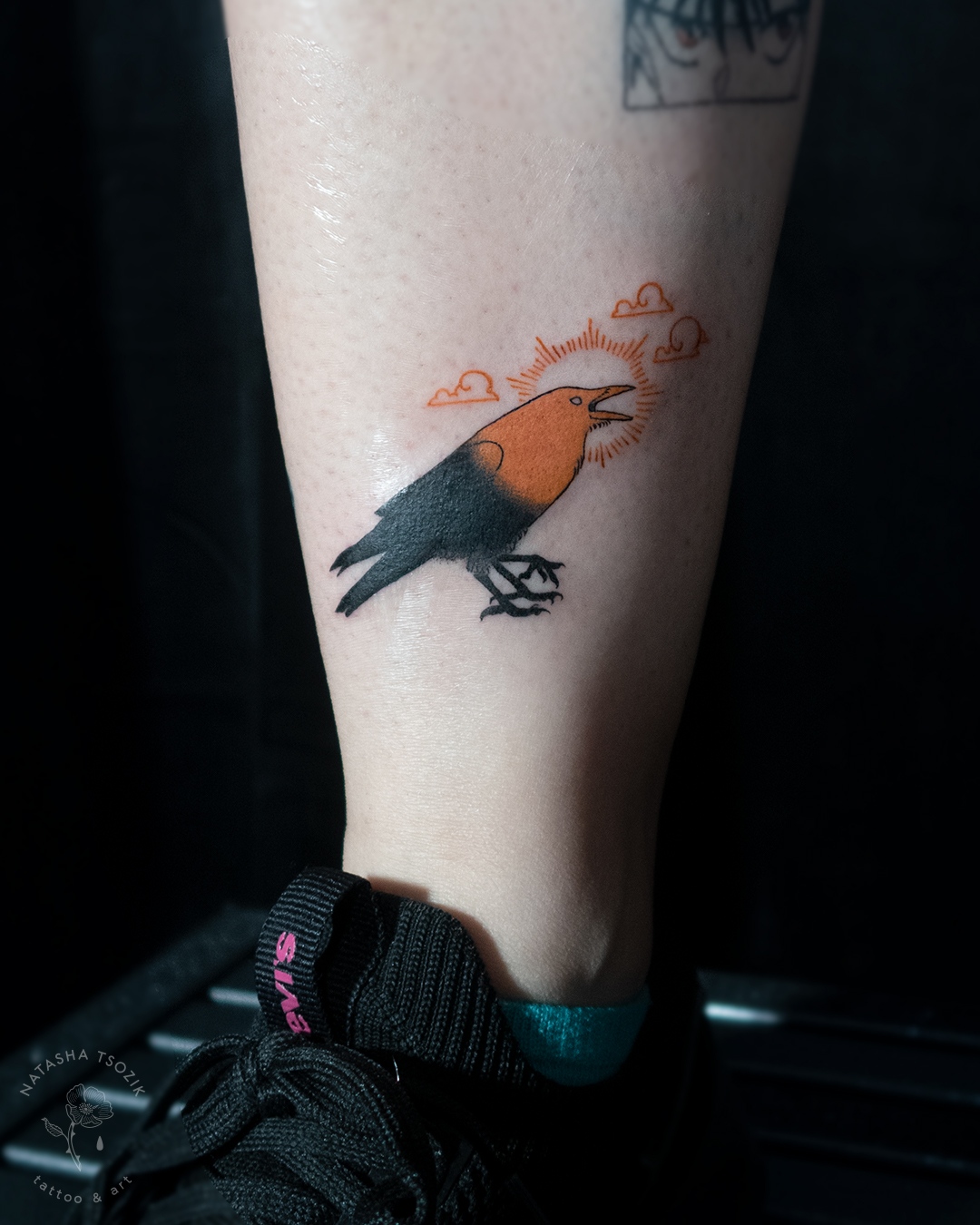 A raven tattoo on a leg