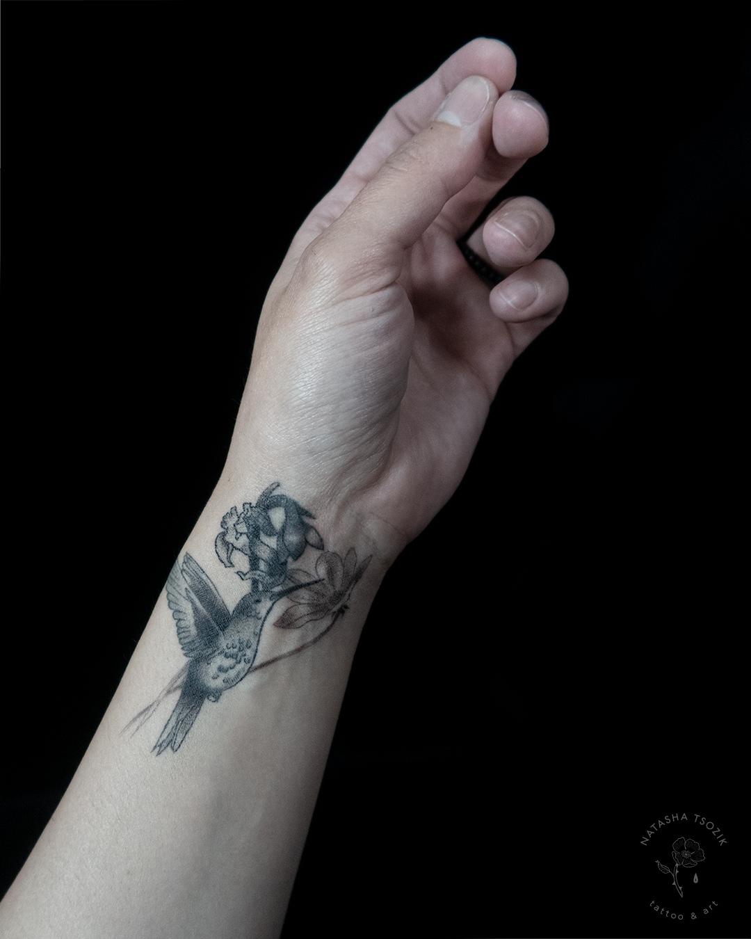 Healed matching hummingbird tattoo on a wrist.
