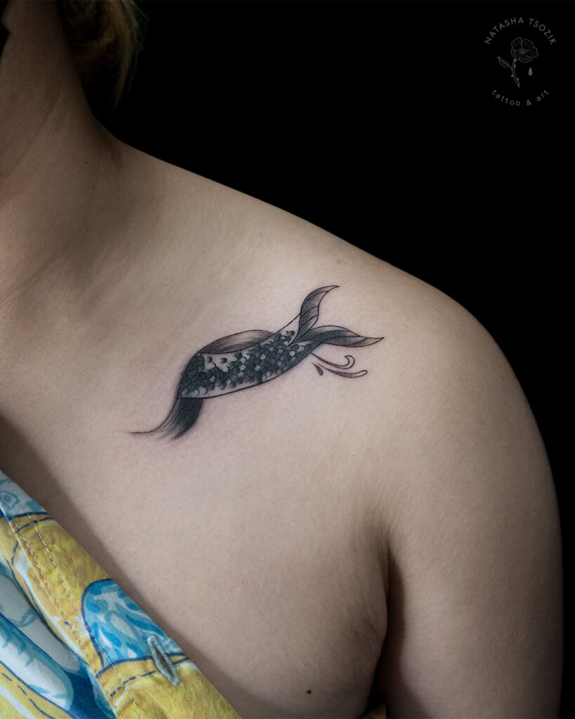 Mermaid tail tattoo on a collarbone.
