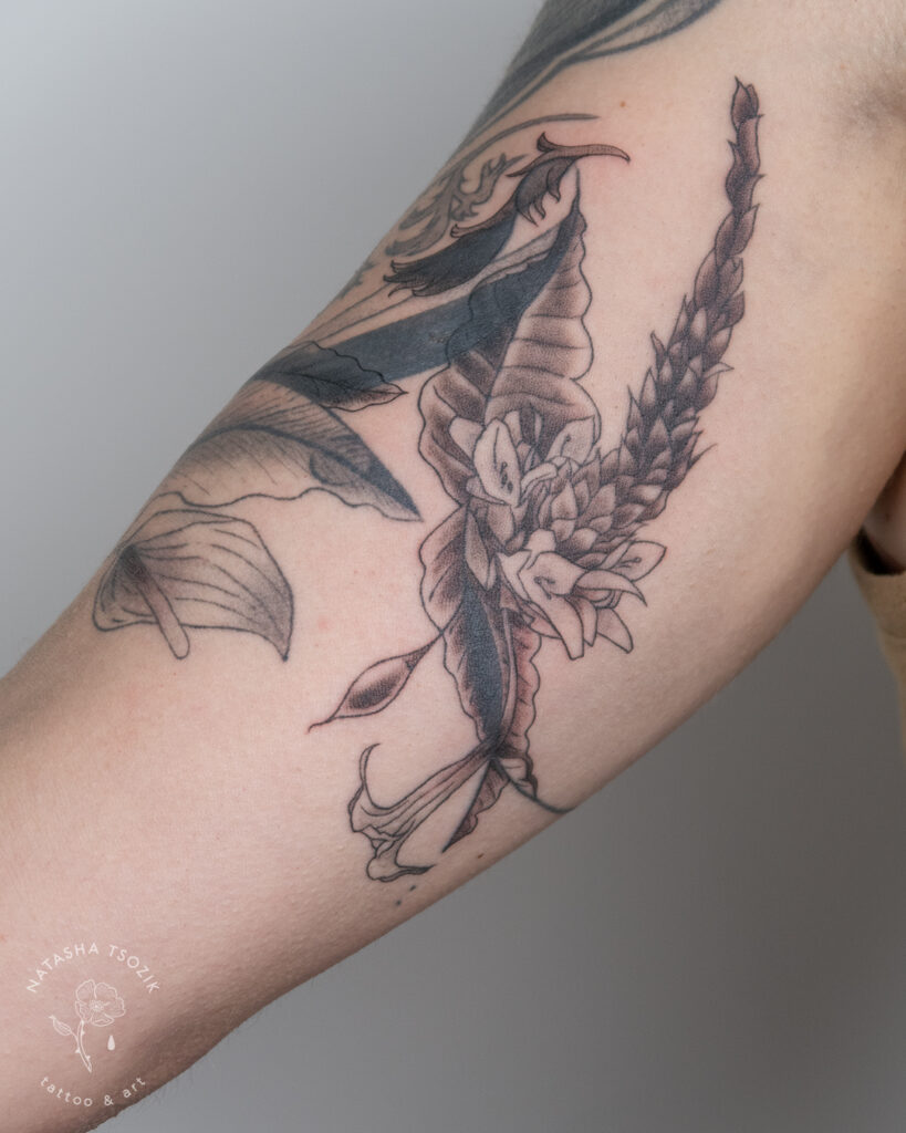 Flower tattoo on a bicep by Natasha Tsozik.
