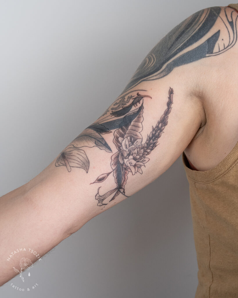 Flower tattoo on a bicep by Natasha Tsozik.