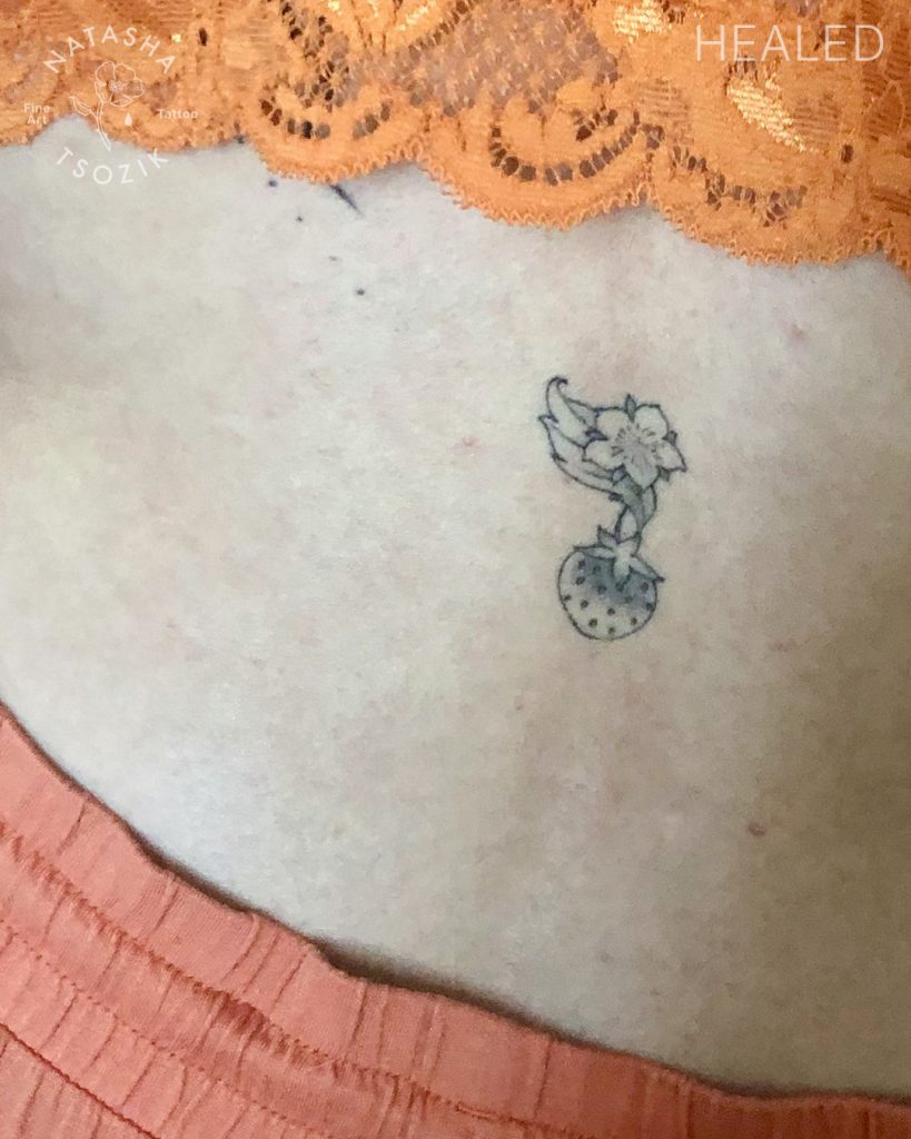 Healed small strawberry tattoo by Natasha Tsozik.